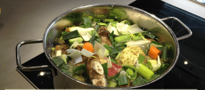 Zubereitung einer selbstgemachten Hühnerbrühe im Topf