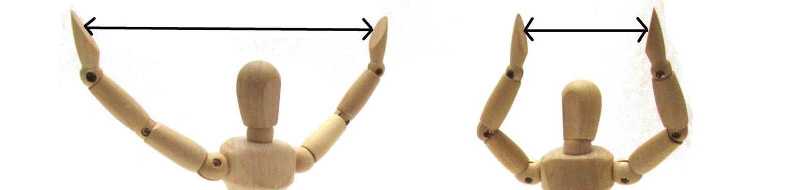 Zwei Holzfiguren vergleichen die Spannweite ihrer Arme