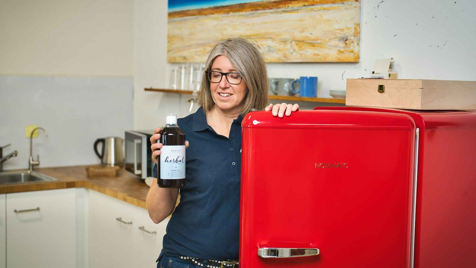 Julia Gruber vor einer offenen Kühlschranktür mit Colostrum in der Hand