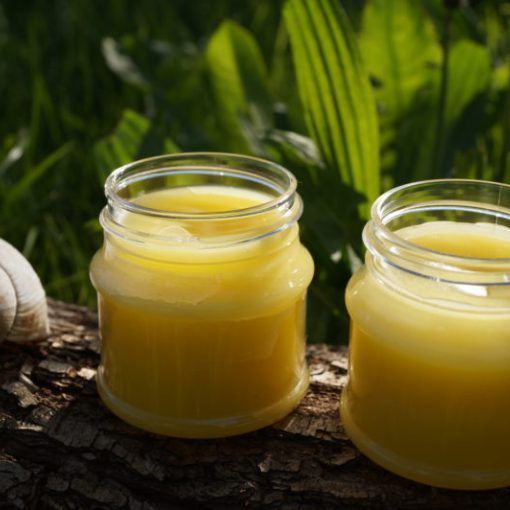 Selbstgemachte Naturkosmetik im Glas vor grünem Hintergrund