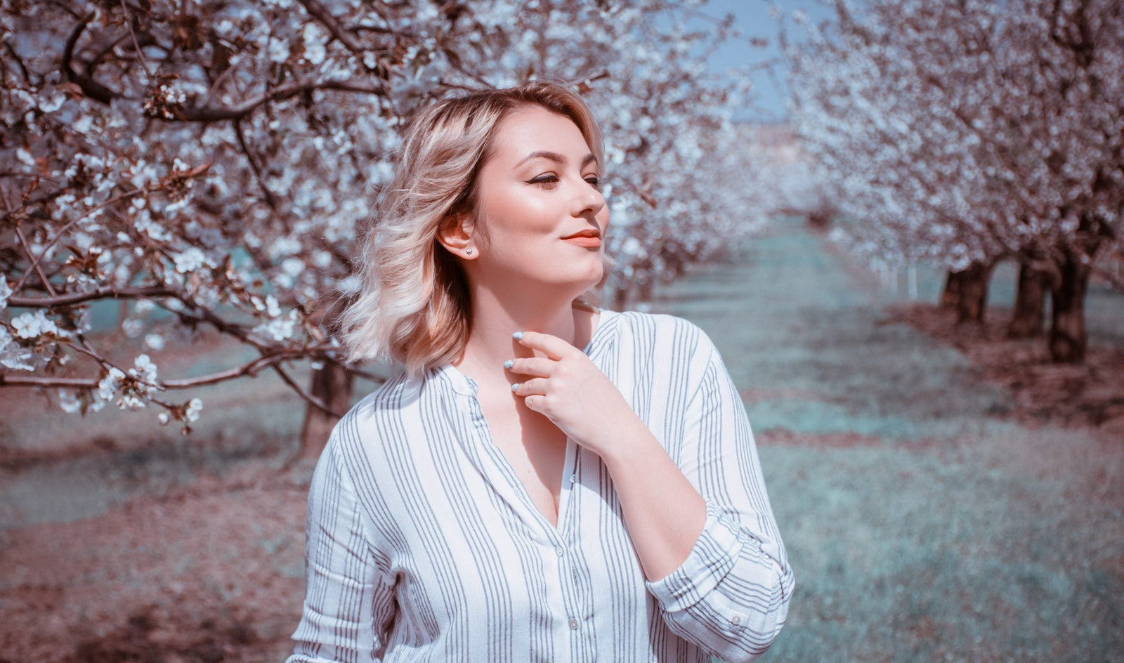 Frau läuft durch Natur mit blühenden Kirschbäumen