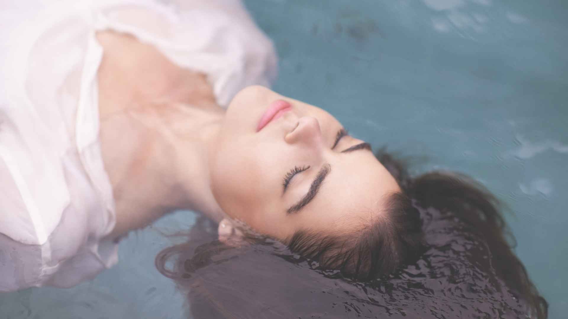 Frau liegend, mit geschlossenen Augen als Symbol dafür auf seinen Körper zu hören