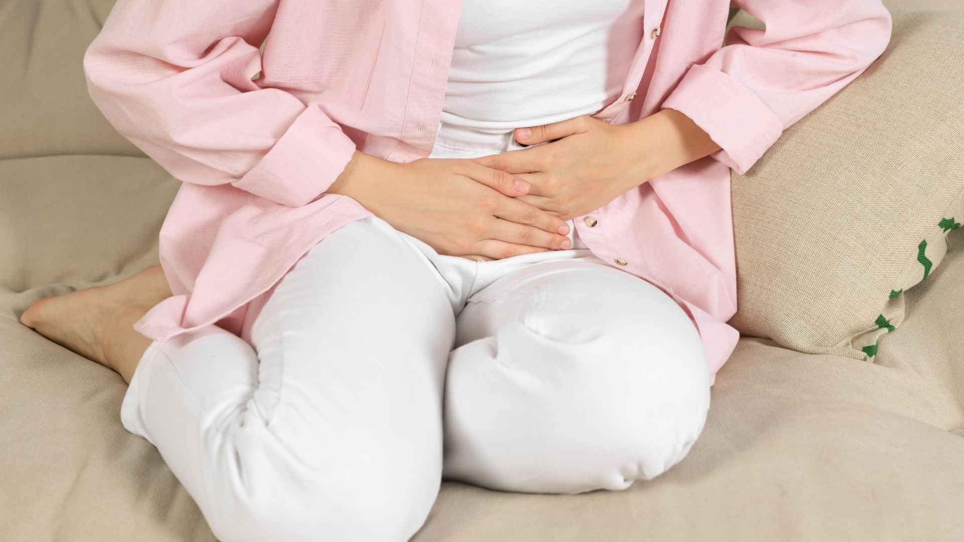 Frau die sich vor Schmerzen den Unterbauch hält