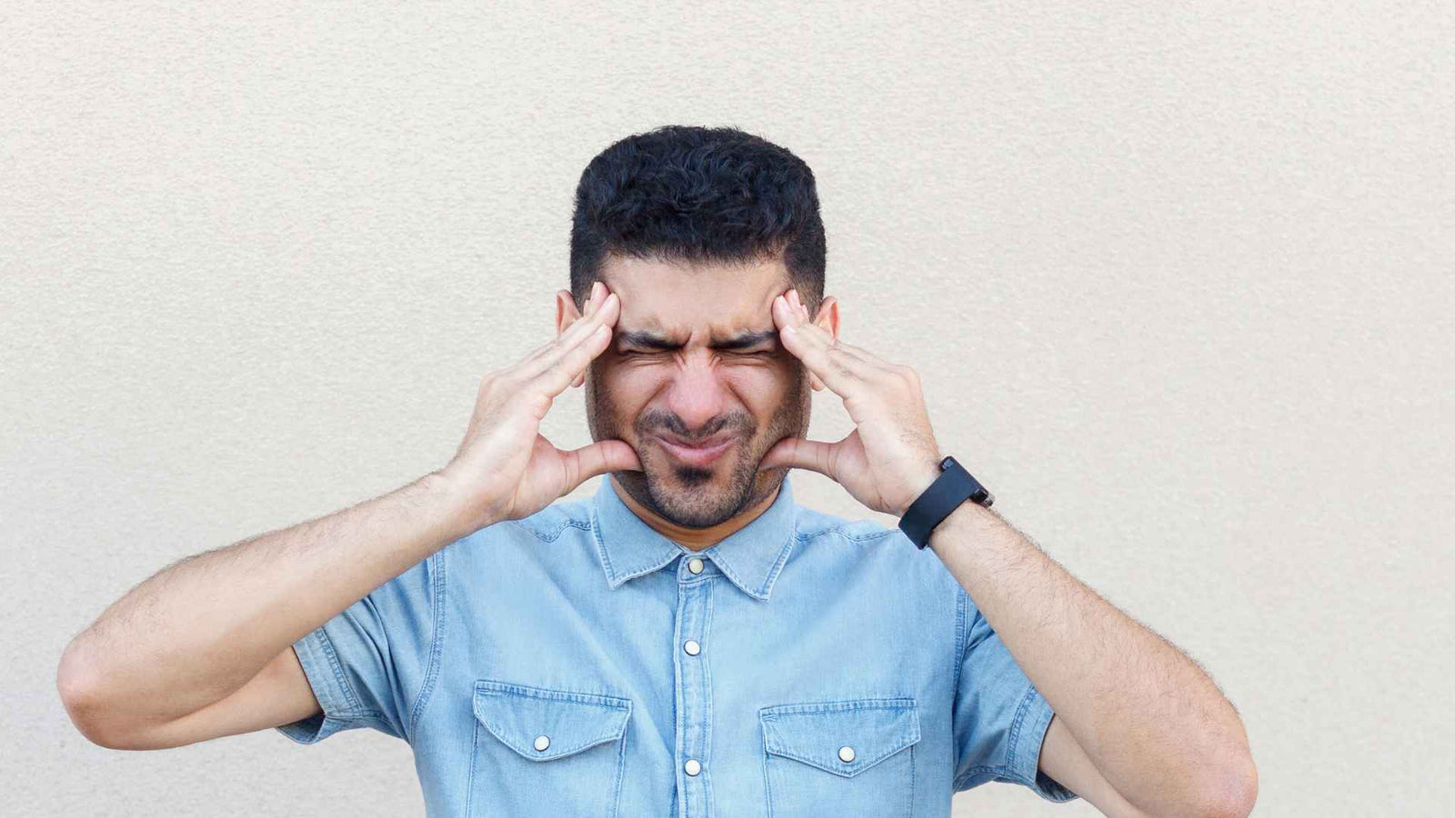 Mann der sich vor Schmerzen den Kopf hält