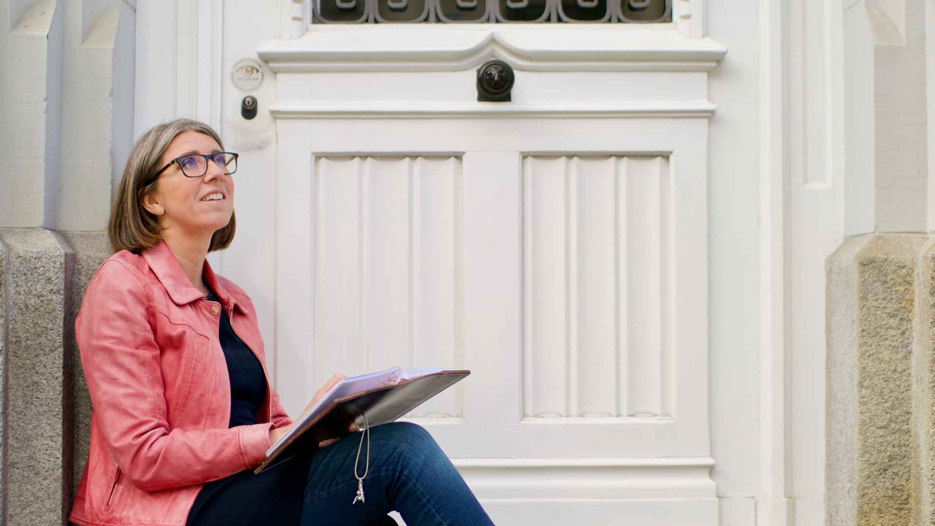 Julia auf einer Treppe sitzend und Tagebuch schreibend