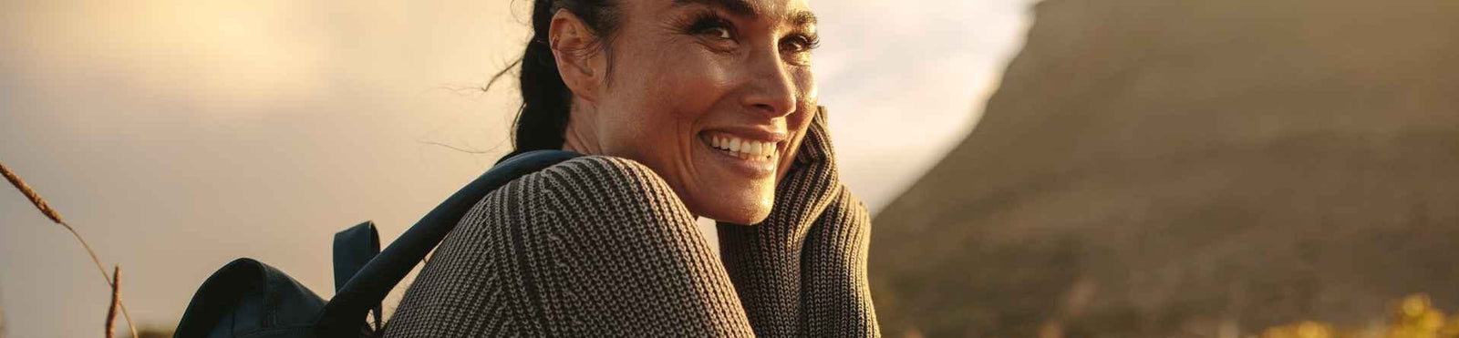 Frau draussen sitzend mit Rucksack