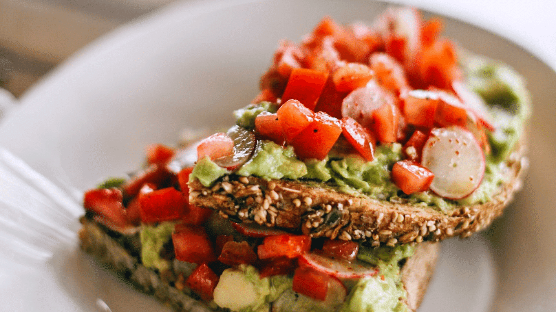 Brot mit Tomate und Avocado auf weissem Teller