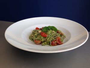Avocado Pesto mit Zucchini Nudeln auf einem Teller angerichtet