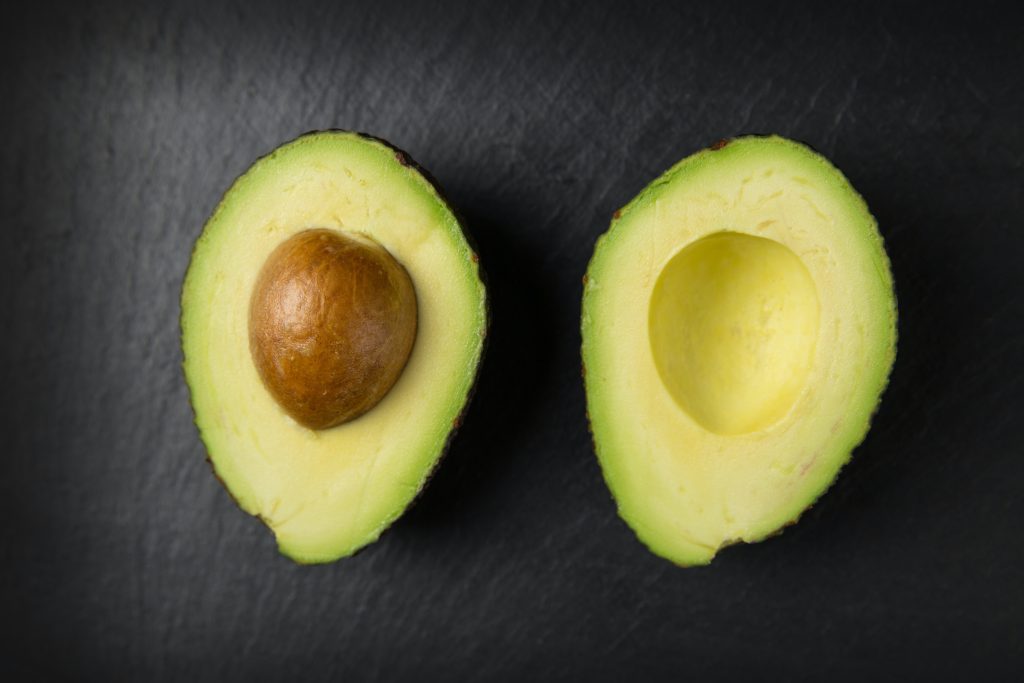 Gesunde Ernährung zum Abnehmen: Eine aufgeschnittene Avocado in zwei Hälften ist ein Teil davon.