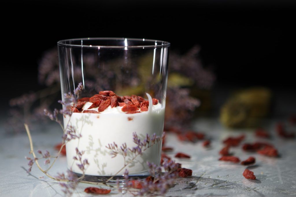 Joghurt und Gojibeeren sind schön aufbereitet in einem Glas mit Dekoration.
