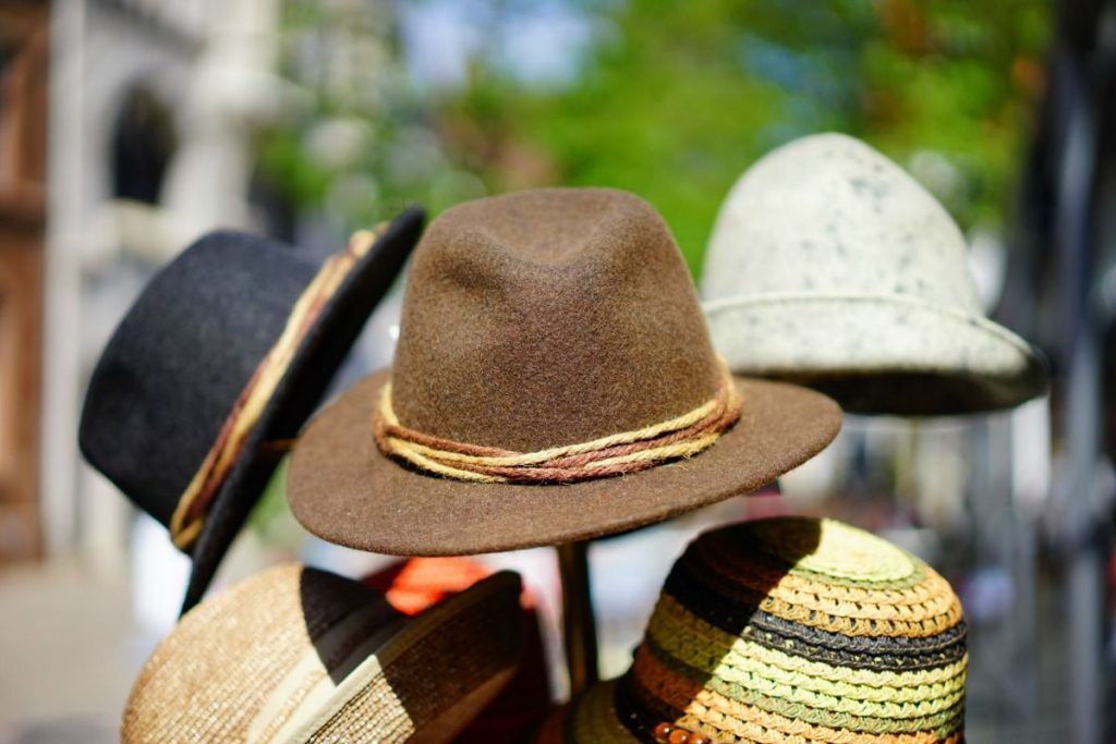 Hüte, die an einer Garderobe zum Verkauf hängen, dienen als natürliche Sonnencreme.