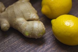 Mit Ingwer und gesunden Zitronen, die auf einer Holzfläche liegen, kann man seine Gesundheit schützen.