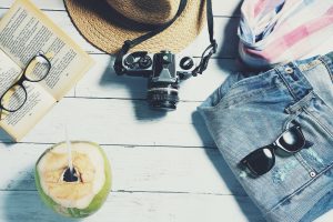 Kokosmuss, Buch, Sonnenhut, Kamera, Sonnenbrille, Shorts und Strandtasche für den Urlaub