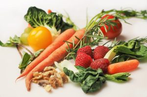 Gesunde Ernährung mit Nüssen, Himbeeren und Gemüse spielt eine wichtige Rolle beim Muskelaufbau