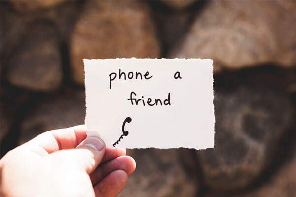 Hand hält Zettel in Hand mit Inschrift "phone a friend"