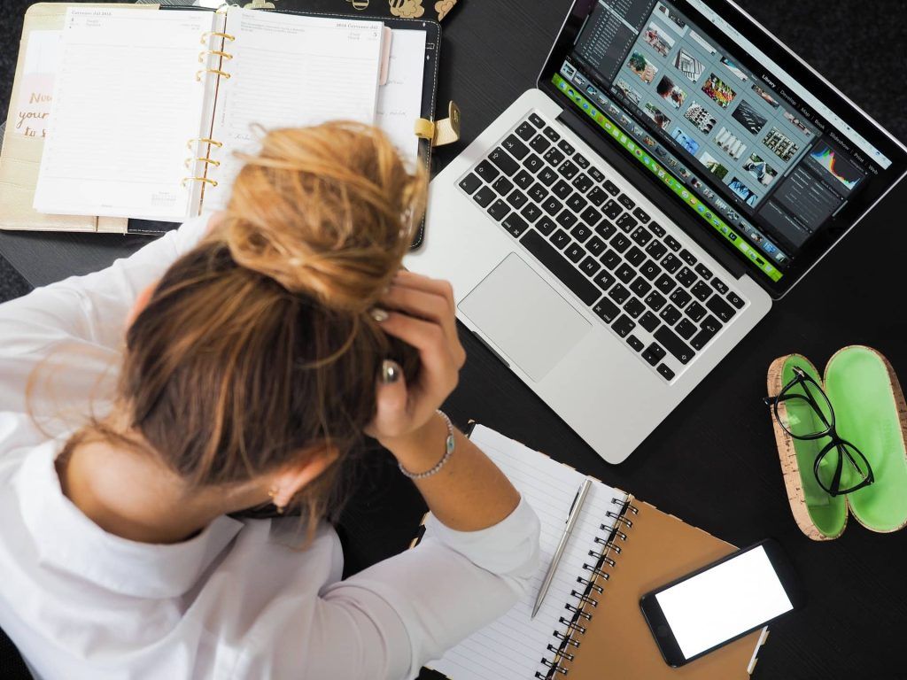 Frau sitzt am Computer und ist verzweifelt. Stress ist eine häufige Ursache von Reizdarm.