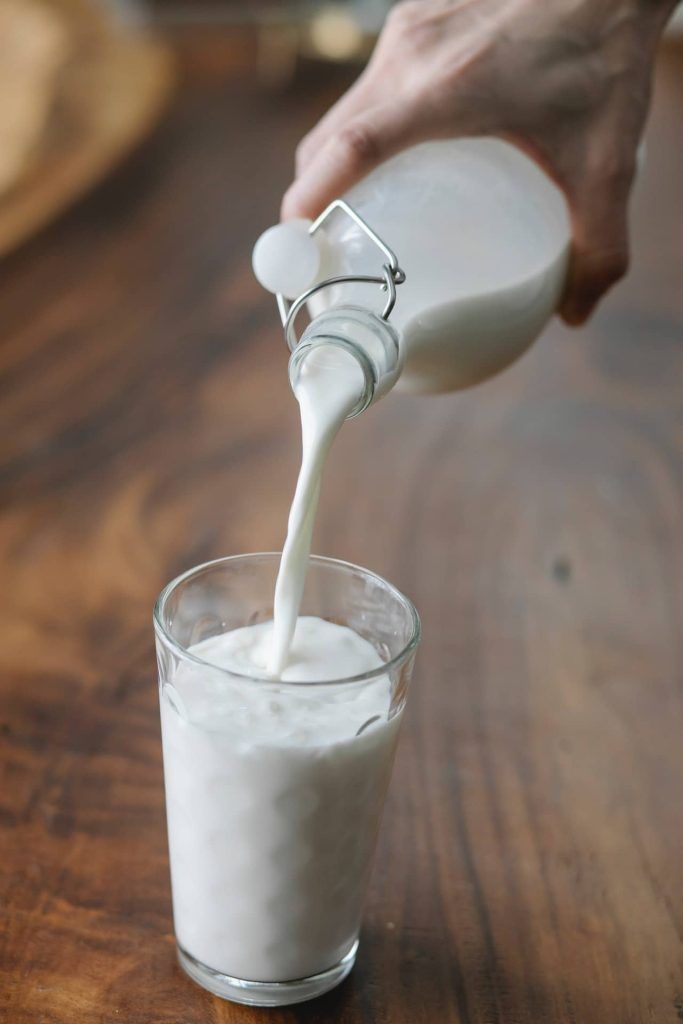 Blähungen können verursacht werden durch Milch aus Glasflasche in ein Glas gegossen