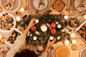Auf dem gedeckten Weihnachtstisch steht das Essen bereit und die Personen müssen später wieder die Weihnachtspfunde verlieren.