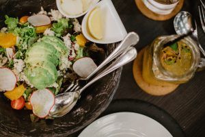 Salat angerichtet mit Besteck und Zitronen in kleinen Schälchen